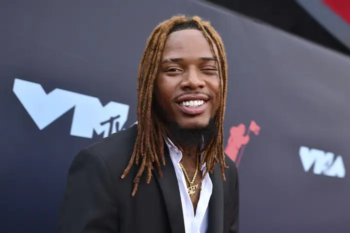 Fetty Wap smiling with wearing a white shirt and black blazer